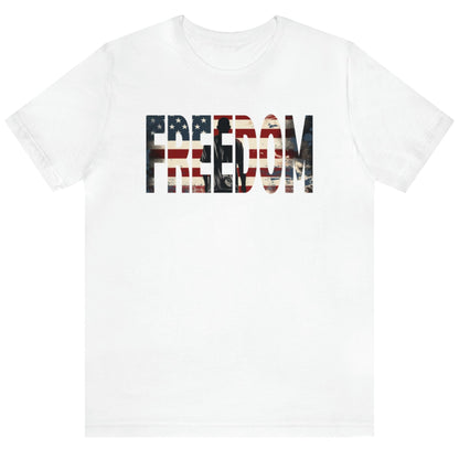 Freedom USA Flag tee, which embodies the spirit of liberty and individualism. An American flag is outlined in the word 'Freedom' with a young man in silhouette gazing toward the stars and stripes, his back turned in reverence.