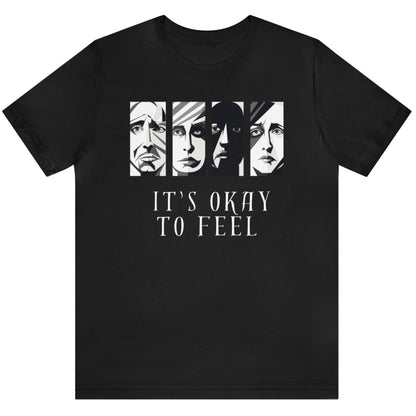 Black mental health awareness t-shirt with four faces arranged horizontally across the shirt with the phrase 'It's Okay to Feel' below. Each face represents real emotions. Perfect for mental health advocates.