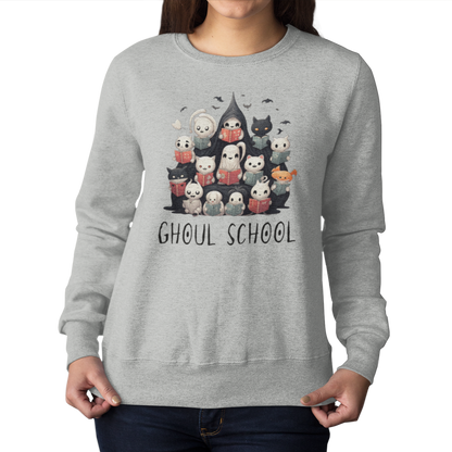 Woman wearing an Ash color Halloween 'Ghoul School' ghost sweatshirt. The graphic showcases a group of cute, stylish ghosts reading books, which creates a spooky classroom scene. The words 'Ghoul School' in a spooky font complete the look. Perfect for teachers, librarians, educators, students, and ghost lovers.