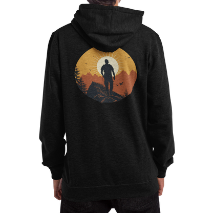 Man wearing a black hoodie with a full back graphic that shows a mountain climber in silhouette staring at a mountain range at sunrise that's covered in an orange haze from the sun.