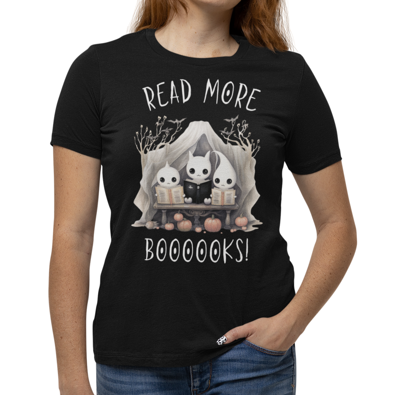 Woman wearing a black Halloween "Read More Boooooks!" tee with a trio of ghosts engrossed in books. Perfect for teachers, librarians, school staff, students, or anyone looking for classroom fun.